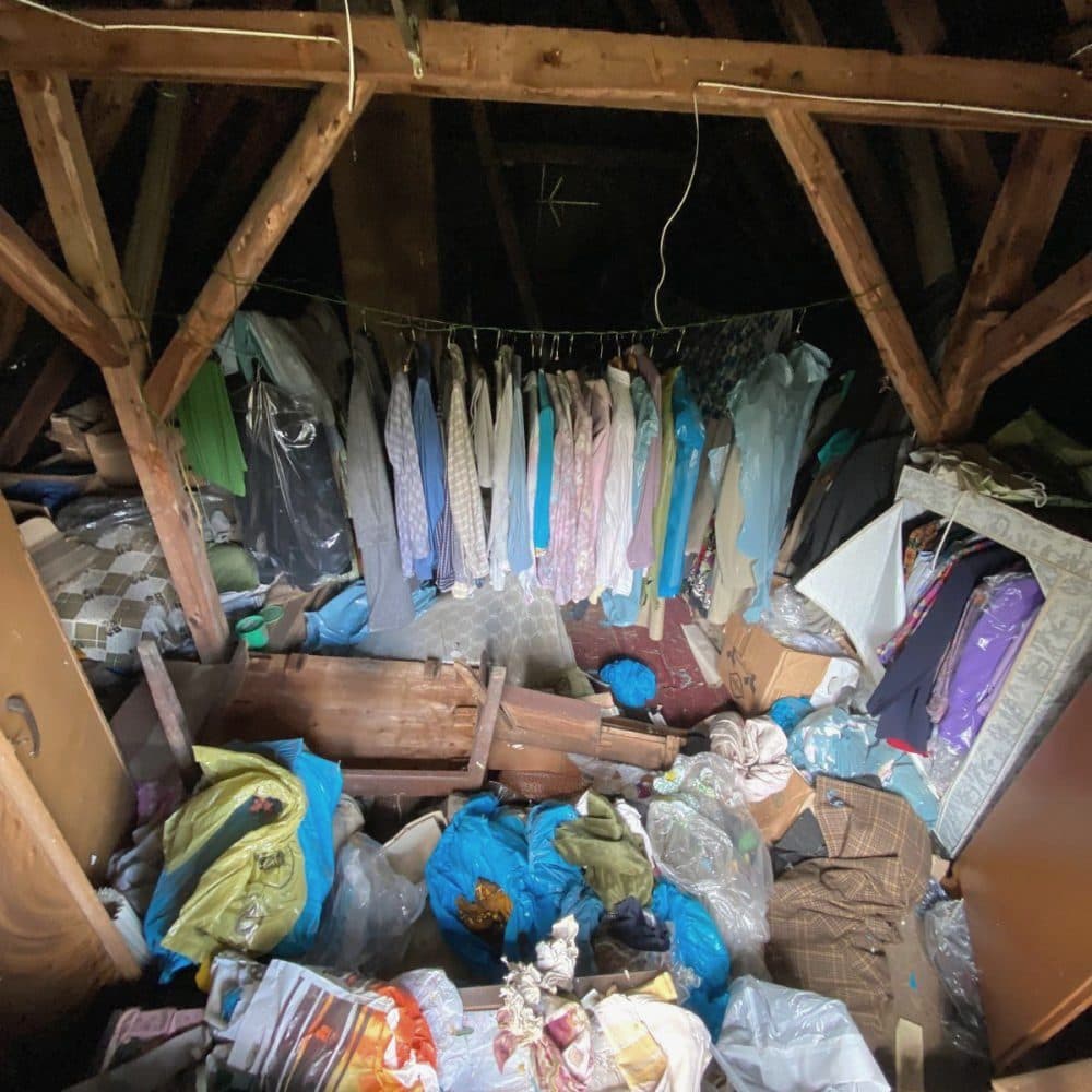 Dachboden mit aufgehängter Kleidung, Säcken und Hausrat