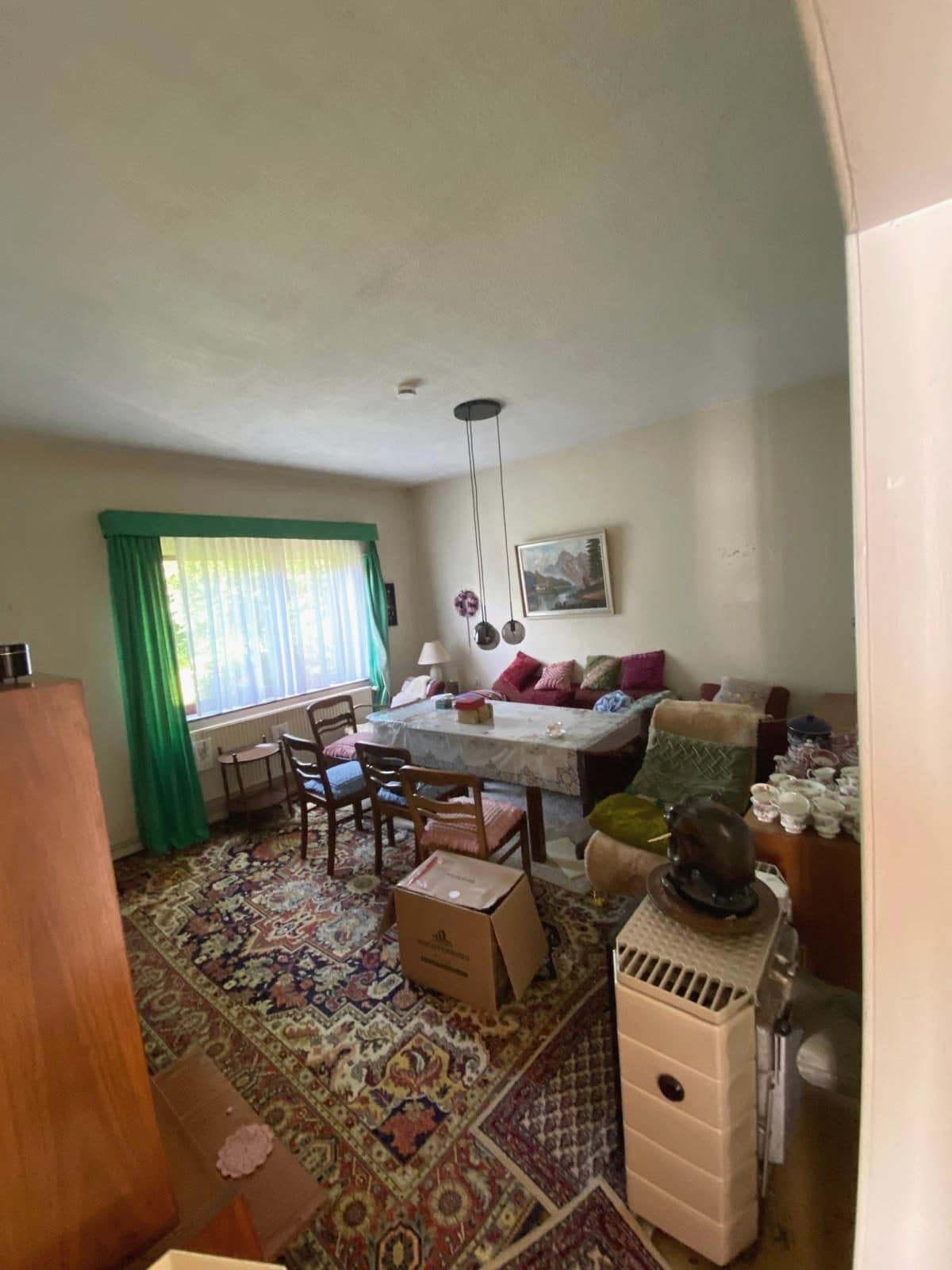 Eingerichtetes Wohnzimmer mit Esstisch, Sofa, Teppichen und Möbeln