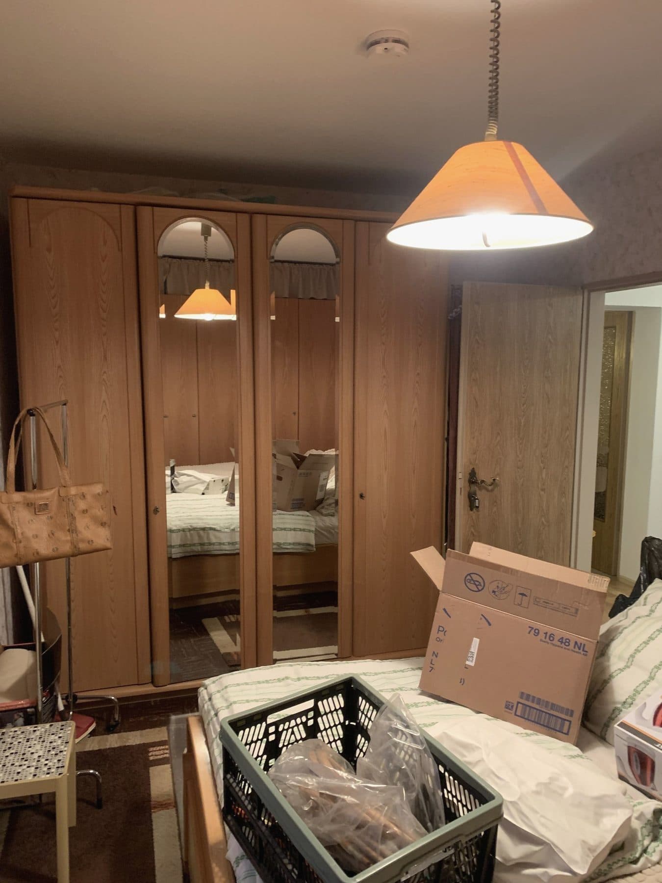 Schlafzimmer mit Kleiderschrank, Bett und Kartons